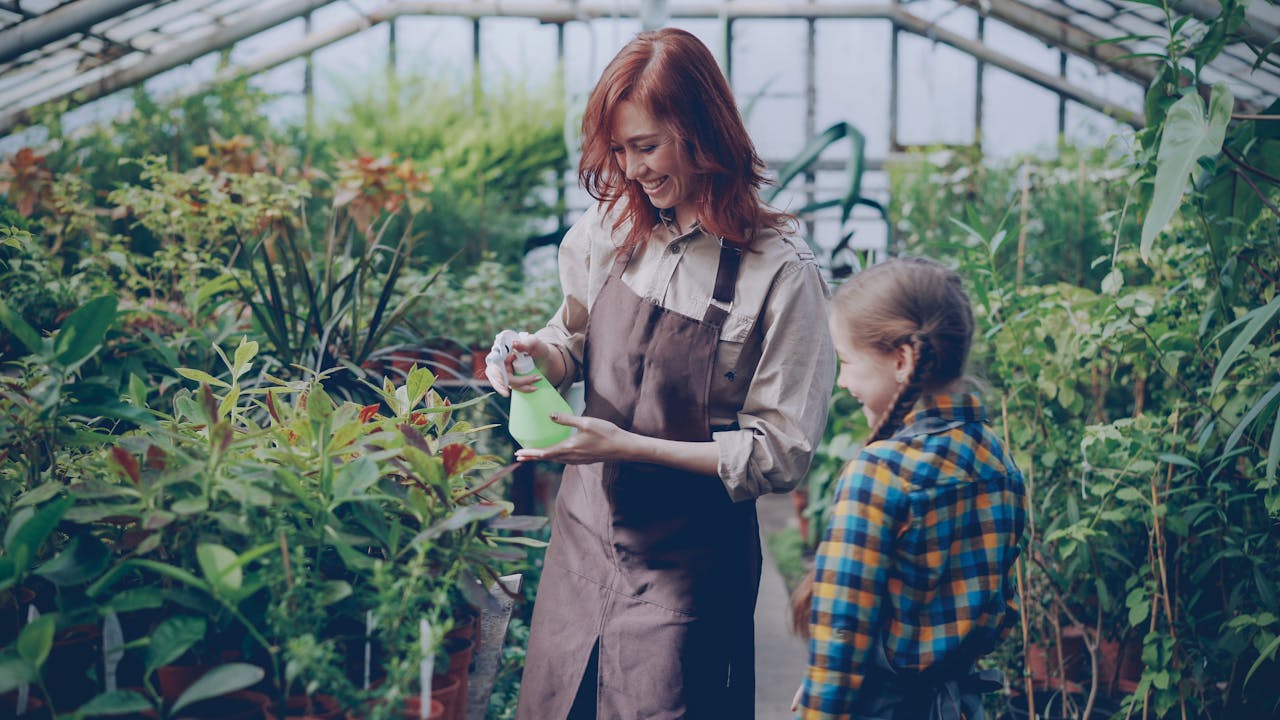 digital-01 A woman and child enjoying gardening together in a greenhouse setting.